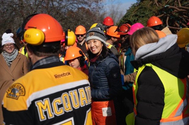 Boston Mayor Michelle Wu, center, is surrounded by students and faculty from Nova Scotia Community College after cutting a white spruce tree from Lunenburg County that was selected as Nova Scotia's 2025 Tree for Boston, in Martins Brook, Nova Scotia last week. (Darren Calabrese /The Canadian Press via AP)