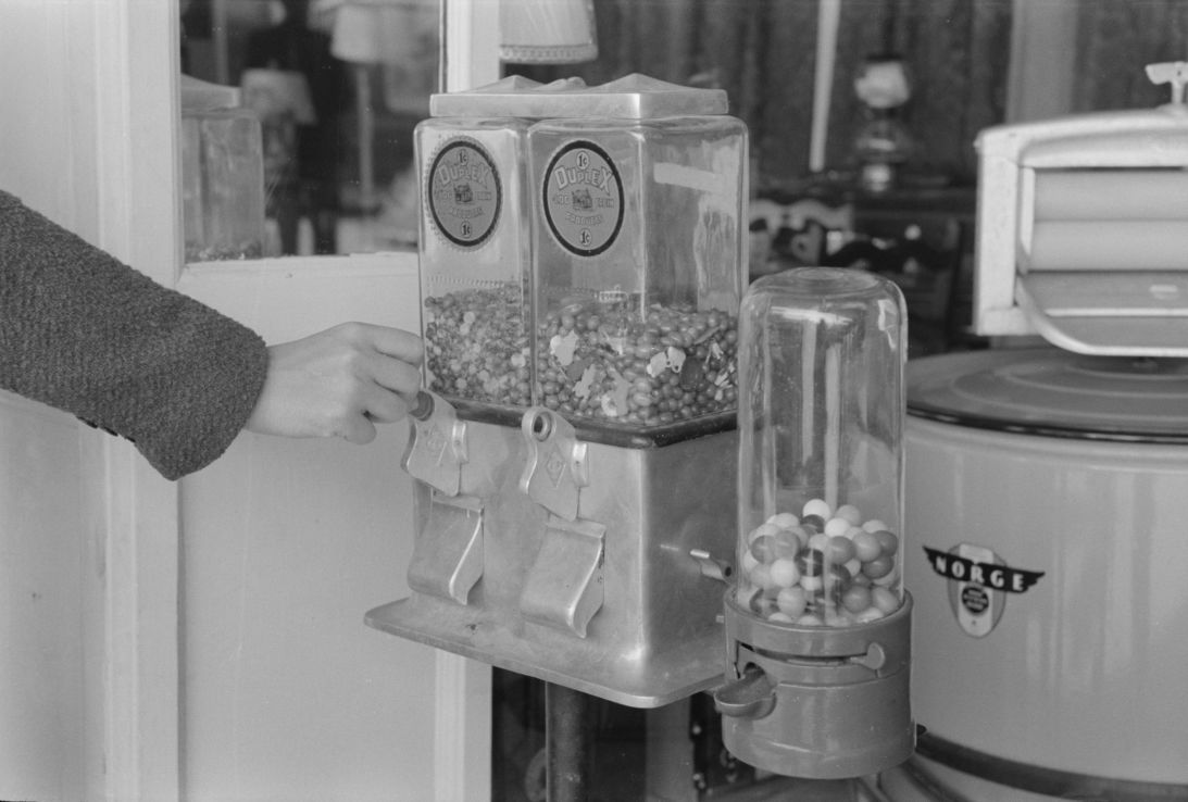 A customer inserts a penny into a candy machine in San Antonio, Texas, in March 1939.