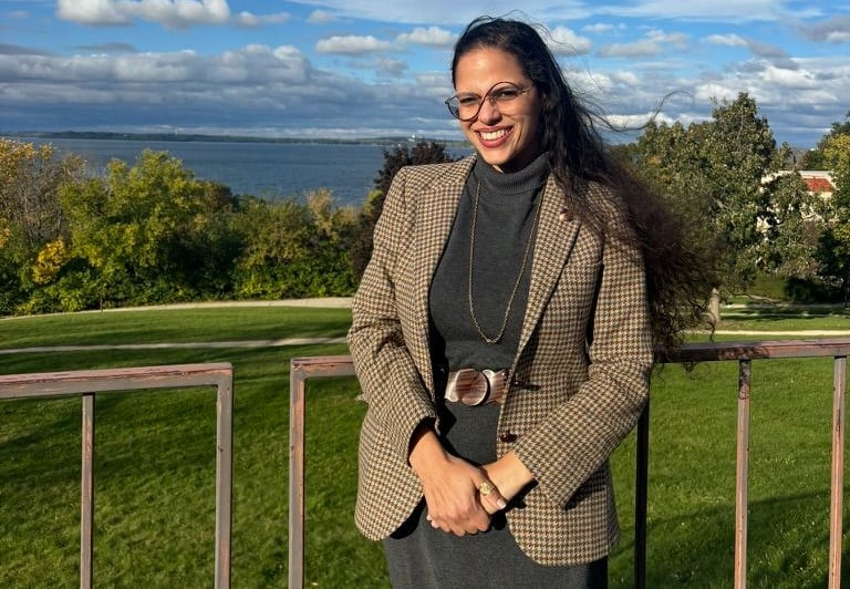 Woman in dress and blazer standing outside