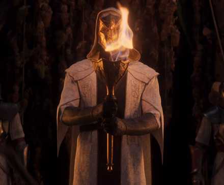 A person in a white coat holding a flaming torch in front of them.