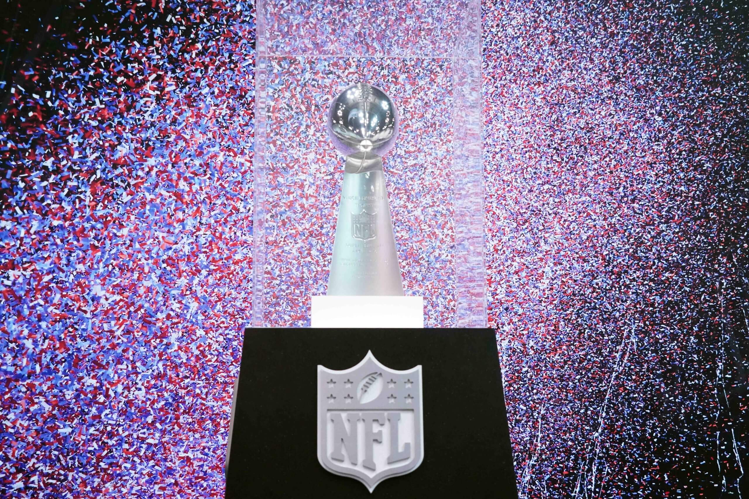 The Lombardi Trophy is pictured behind a glass case and confetti.