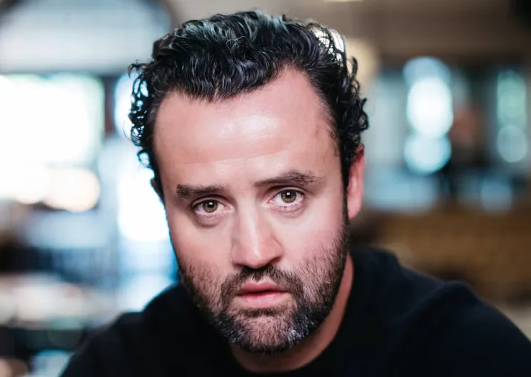 person with curly hair in a cafe setting