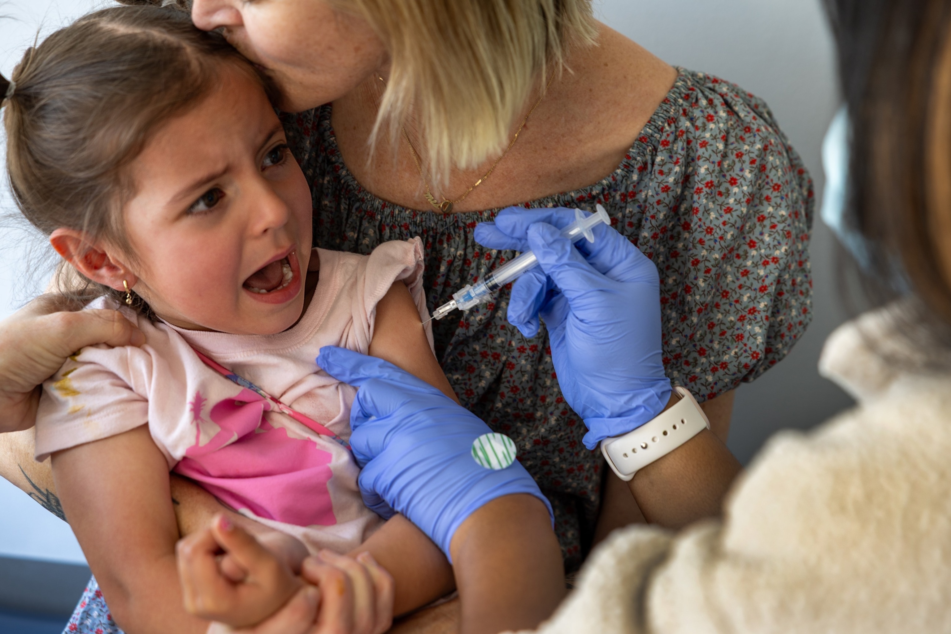 PHOTO: Dr. Neville Anderson, left, helps to hold Iris Behnam, 4, while nurse Breanna Kirby, right, gives her DTap Polio and MMR Chickenpox (Varicilla) vaccinations while her mom, Haley Behnam,in Los Angeles, March 25, 2025.