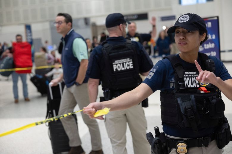 A Department of Homeland Security officer directs passengers at Houston's Bush airport on Wednesday.