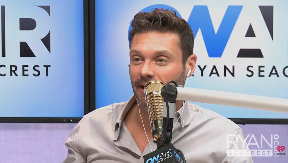 Ryan speaking into a microphone in a radio studio