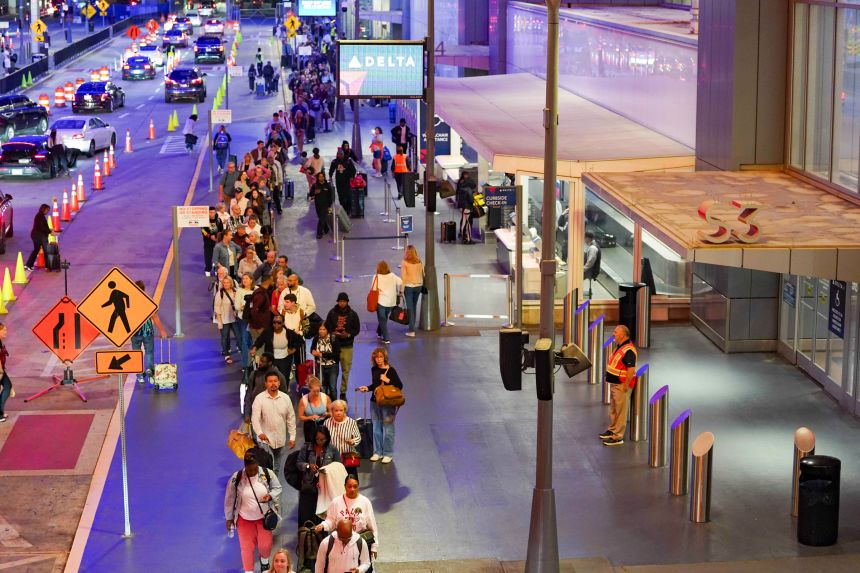 Travelers wait in long lines early in the morning at Atlanta Hartsfield-Jackson International Airport on Friday in Atlanta.