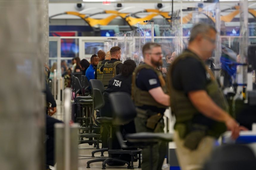 ICE agents check IDs at the security check point in Atlanta Hartsfield-Jackson International Airport on Thursday.
