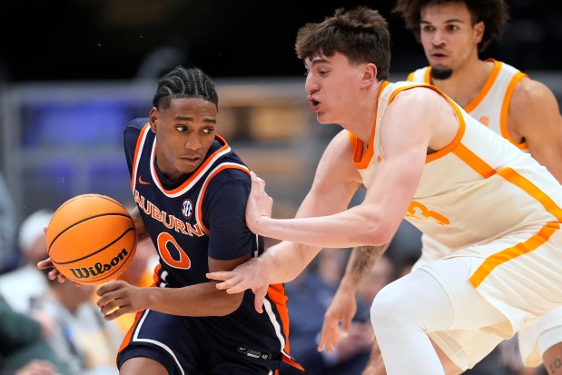 Auburn guard Tahaad Pettiford dribbles the ball past Tennessee forward J.P. Estrella during the second half of a game in the second round of the SEC tournament Thursday, March 12, 2026, in Nashville, Tenn. (AP Photo/George Walker IV)