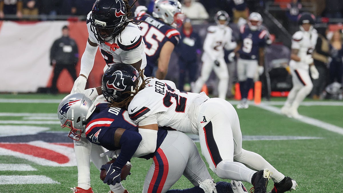 Stefon Diggs catching a touchdown pass against Jaylen Reed and Calen Bullock in a football game